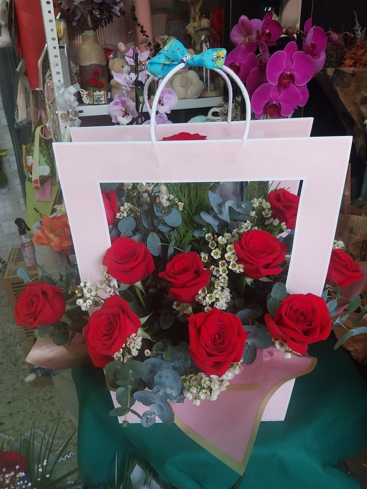 Bolsa de regalo con orquídeas y rosas rojas